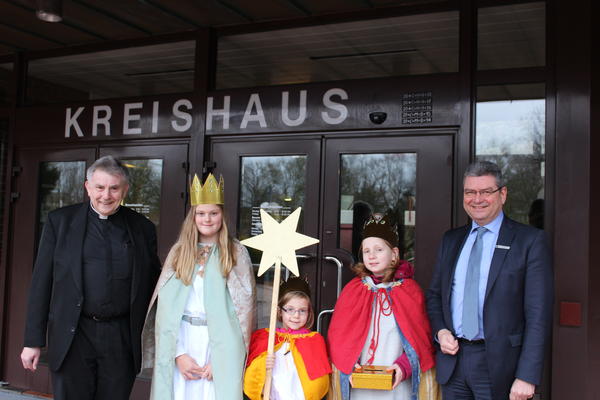 Auf dem Foto sehen Sie Pastor Trenkamp, Ida und Greta Hennen sowie Theresa Schulte mit Landrat Jörg Bensberg.