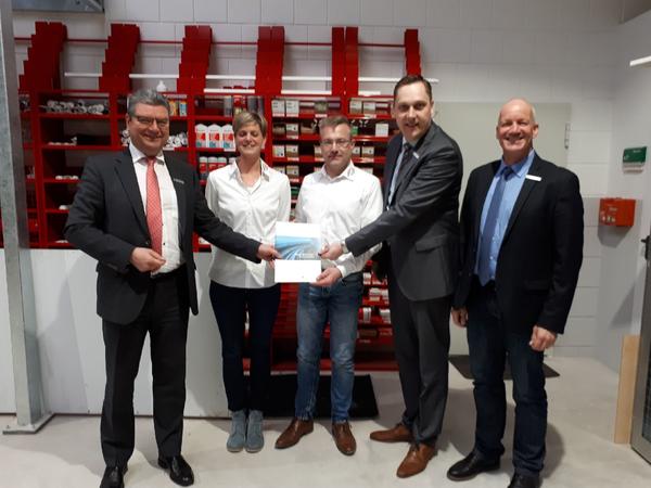 Landrat J�rg Bensberg �berreicht zusammen mit B�rgermeister Matthias Huber (zweiter von rechts) und Kreiswirtschaftsf�rderer Fred Carstens (rechts) Malermeister Matthias Geppert den F�rderbescheid