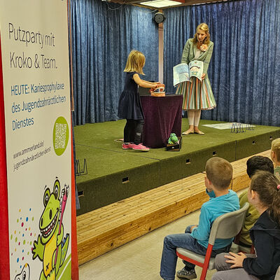 Die Kinderzauberin Jella steht mit einer Grundsch&uuml;lerin auf der B&uuml;hne. Die Grundsch&uuml;lerin darf bei einem Zaubertrick helfen.