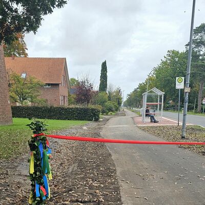 Das Bild zeigt den neuen Radweg. In der Mitte des Bildes ist ein rotes Band zusehen.